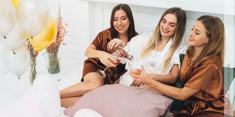 Frauen trinken Wein im Bett