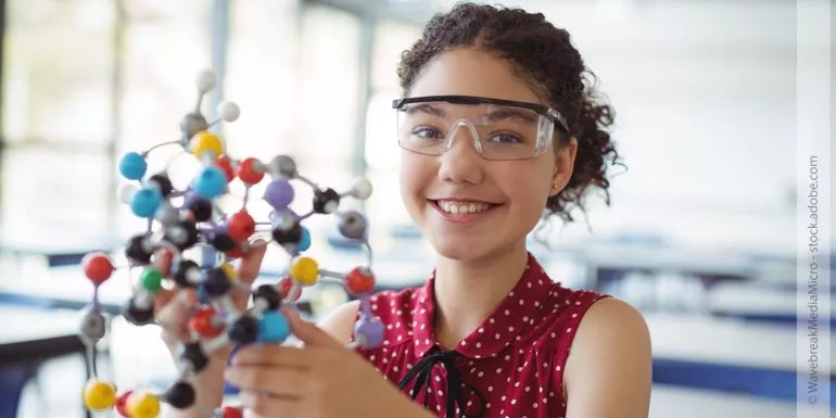 Ein Mädchen hält ein Molekülmodell in ihren Händen