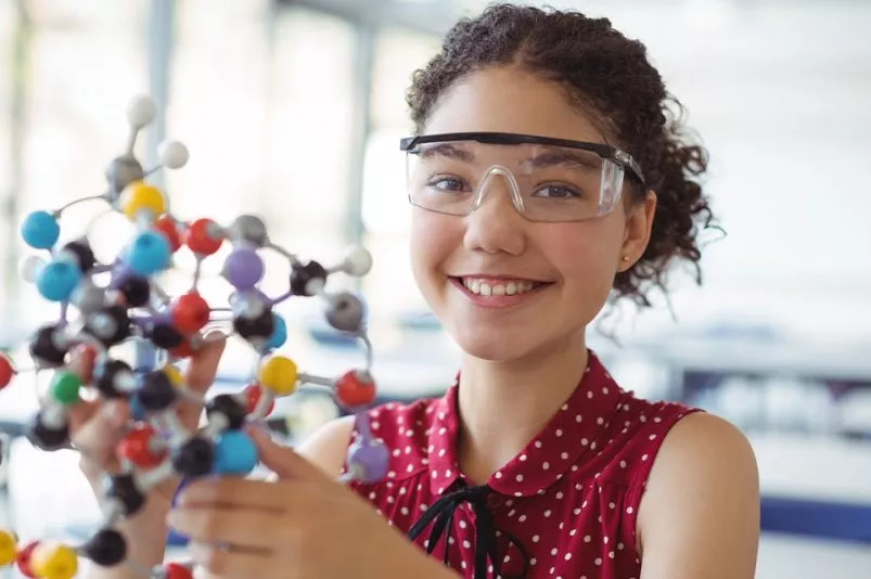 Ein Mädchen hält ein Molekülmodell in ihren Händen